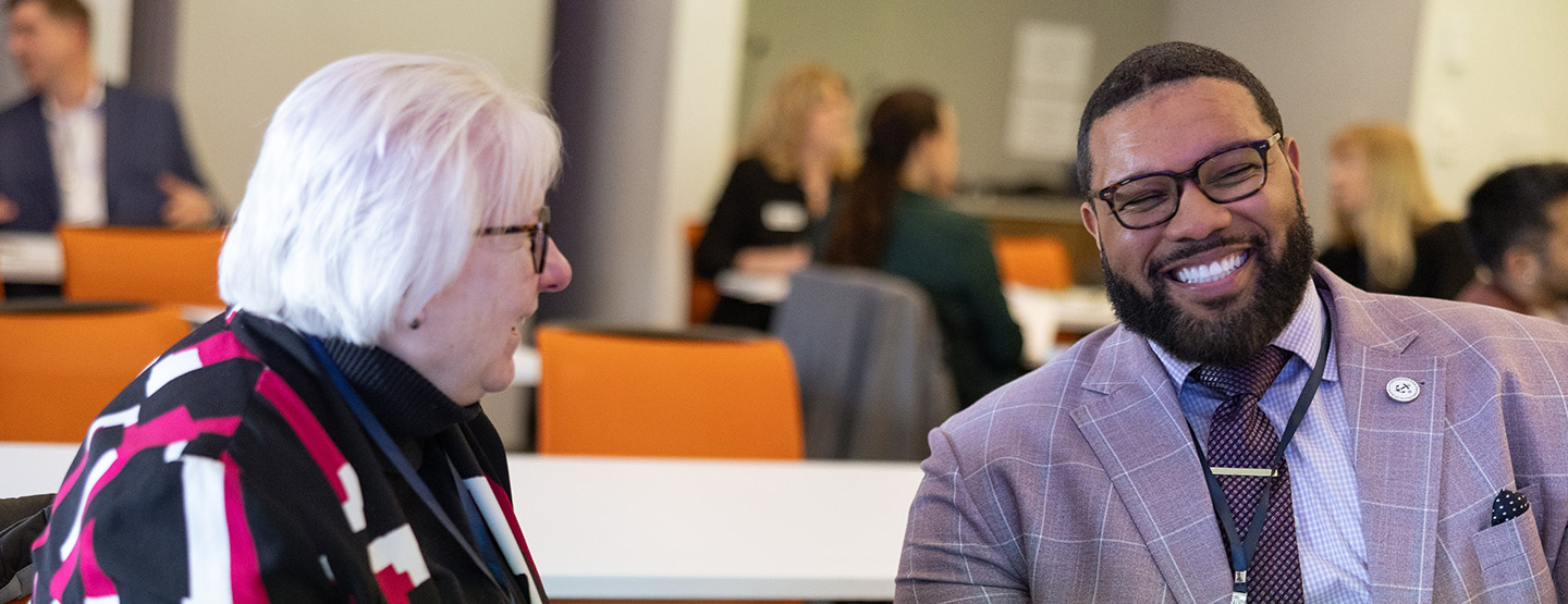 Two colleagues discuss a recent report release at the Annenberg Institute at Brown