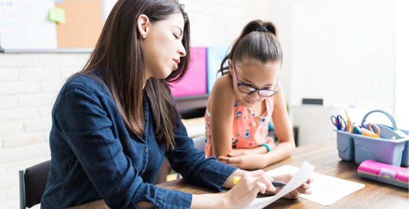 Teacher and student working together at a desk