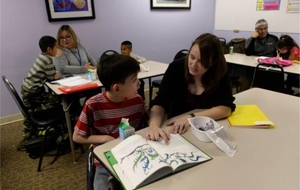 A tutor guides a young student through a reading lesson