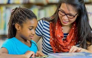 A tutor reads with a young student