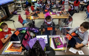 Kindergarten students working at desks with dividers