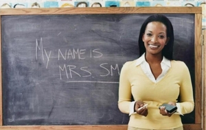 A substitute teacher in front of a chalkboard