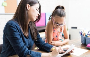Teacher and student working together at a desk