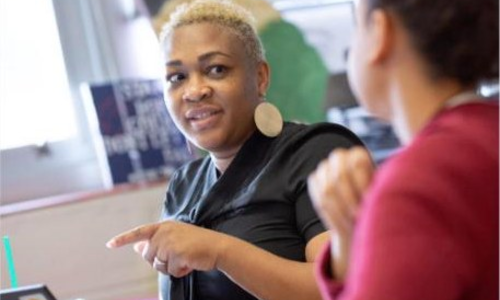 Two teachers talking in a classroom