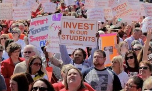 Teachers rallying with Invest in Our Students signs
